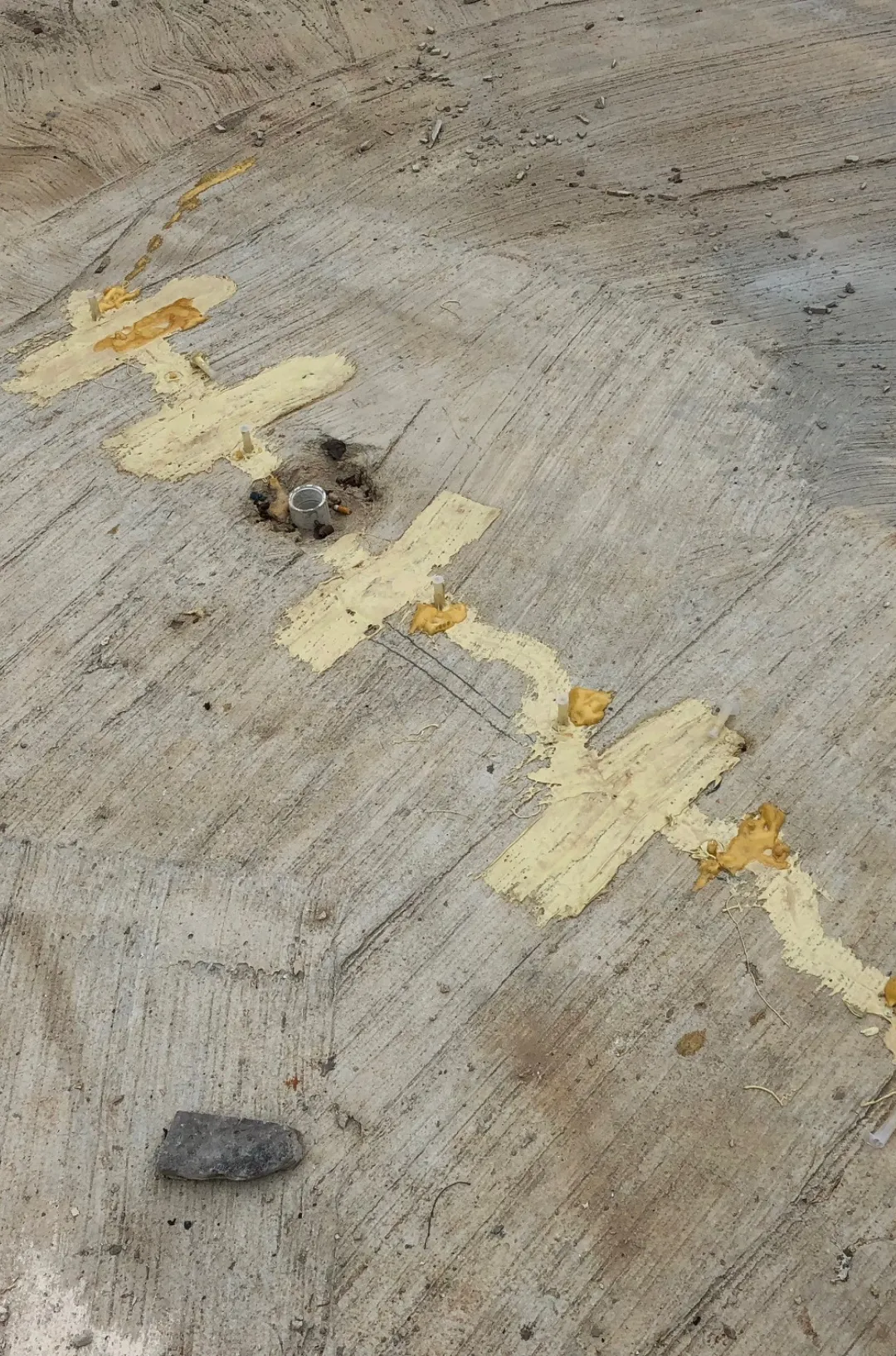 Reconstruction of a swimming pool in progress by Alpha Pool Renovations, showing workers and equipment restoring the pool structure.