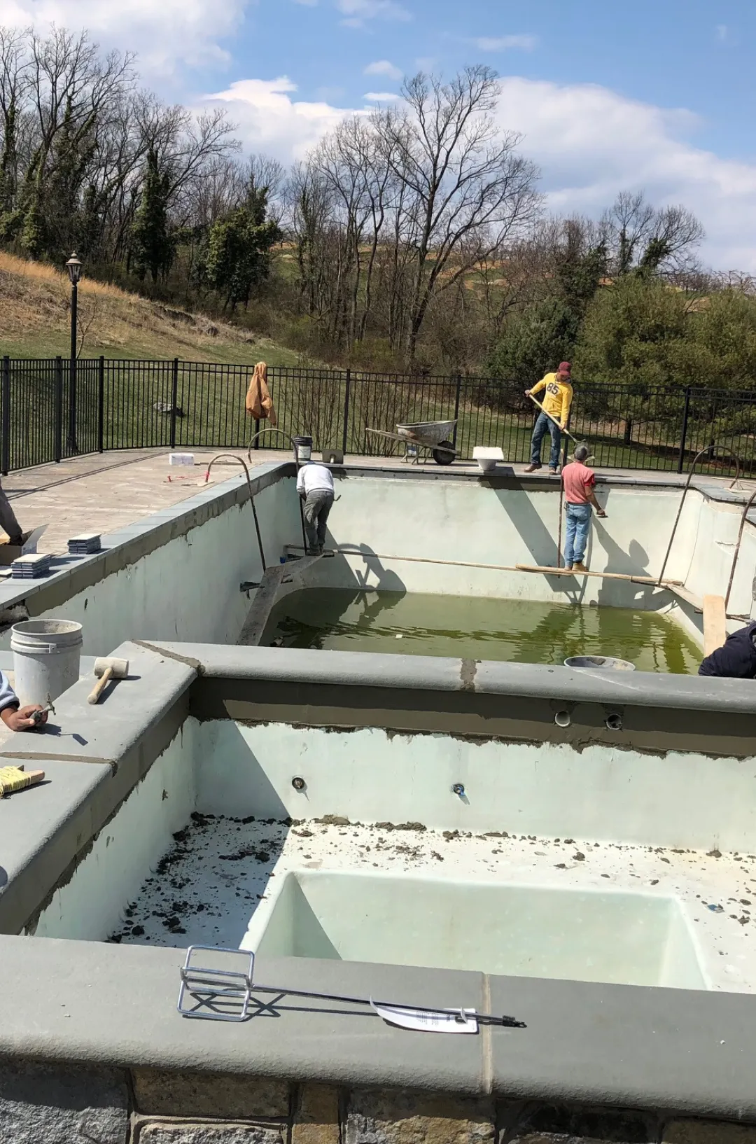 Pool resurfacing crew working inside a residential swimming pool in Northern Virginia